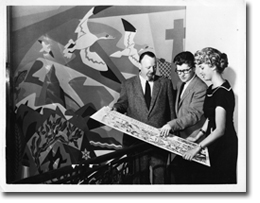 Thor Hansen (left), designer of the mural and art director of the British American Oil Company showing the plan of the mural to Umberto Bruni (centre) and an unidentified woman, 1957.
