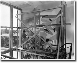 Artist Umberto Bruni, with his nephew, in the process of painting the mural in the Mont-Royal office of the British American Oil Company, 1957. The building was owned by St. Lawrence Cement from 1994 to 2008.
