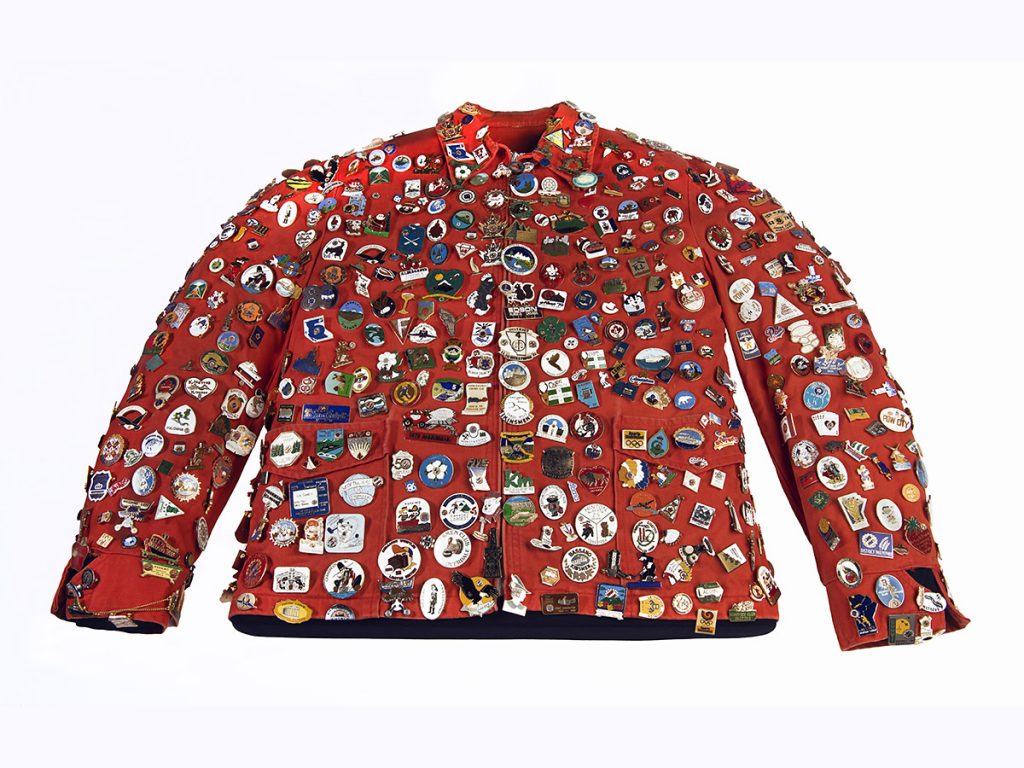 A red jacket covered in colourful lapel pins
