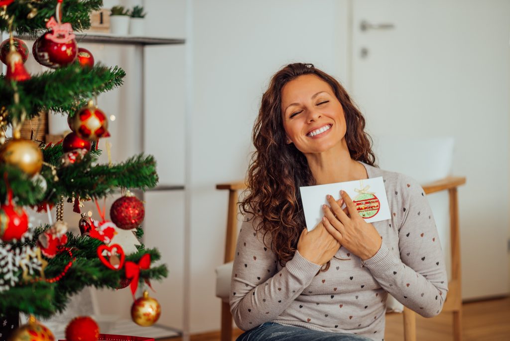 Portrait of a Woman with eyes closed, happy to receive a holiday card