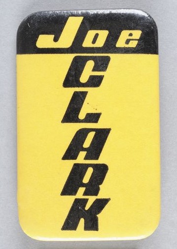 Yellow and black button with Joe written horizontally and Clark written vertically.