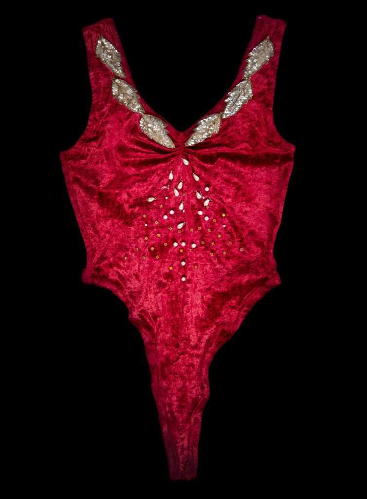 A skimpy, bright red bodysuit decorated with sequins.