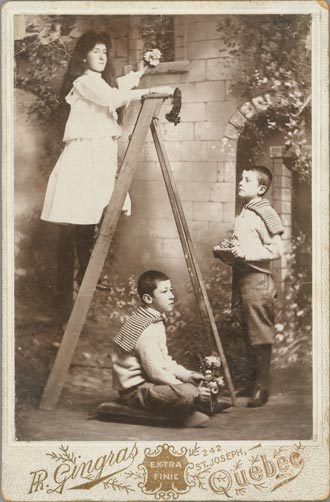 Photograph of three children in a garden - two boys and a girl on the ladder