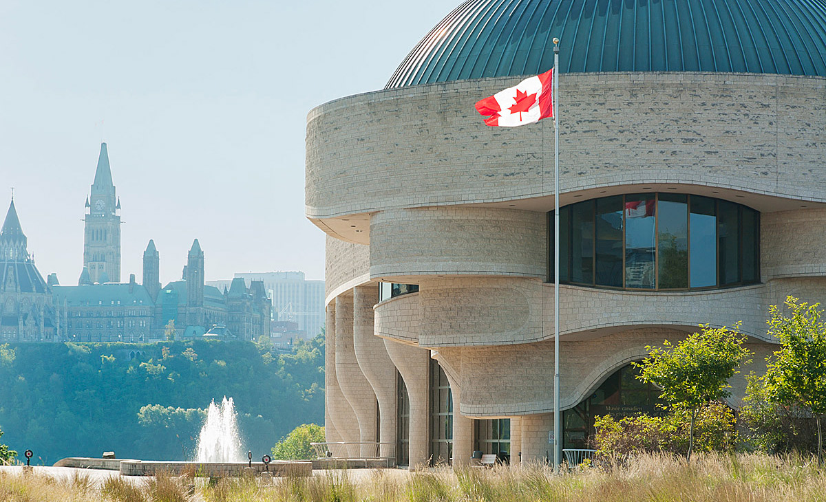 The Canadian Museum of History, located in Ottawa, proudly displays a Canadian flag flying in front of its building.