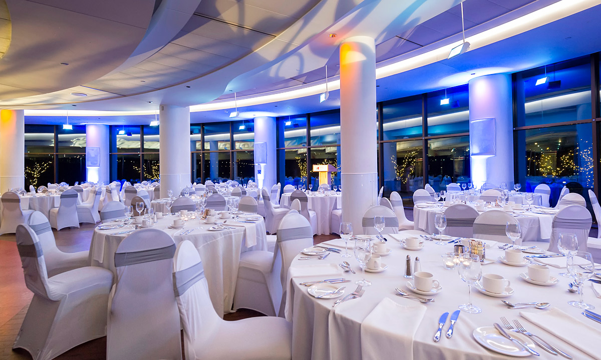 A large banquet hall with white tables and chairs, located in Ottawa at the Canadian Museum of History.