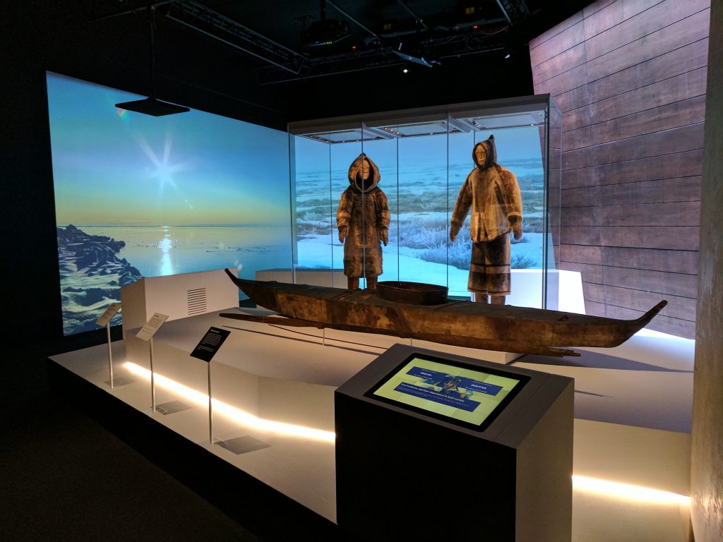 Un kayak et des tenues d’été inuits, datant tous de plus de 100 ans, au National Maritime Museum. La station d’écoute (en bas à droite) permet d’écouter Louie Kamookak expliquer l’importance constante de la tradition orale inuite. Photo Musée canadien de l'histoire 