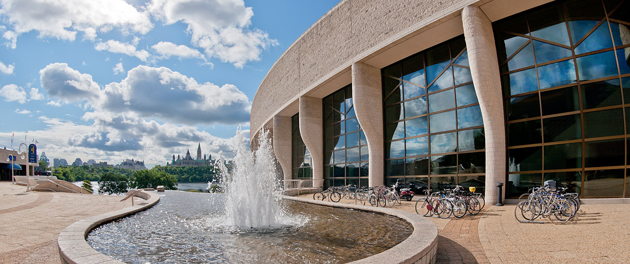 A fountain in front of the Canadian Museum of History with bicycles parked in front of it.