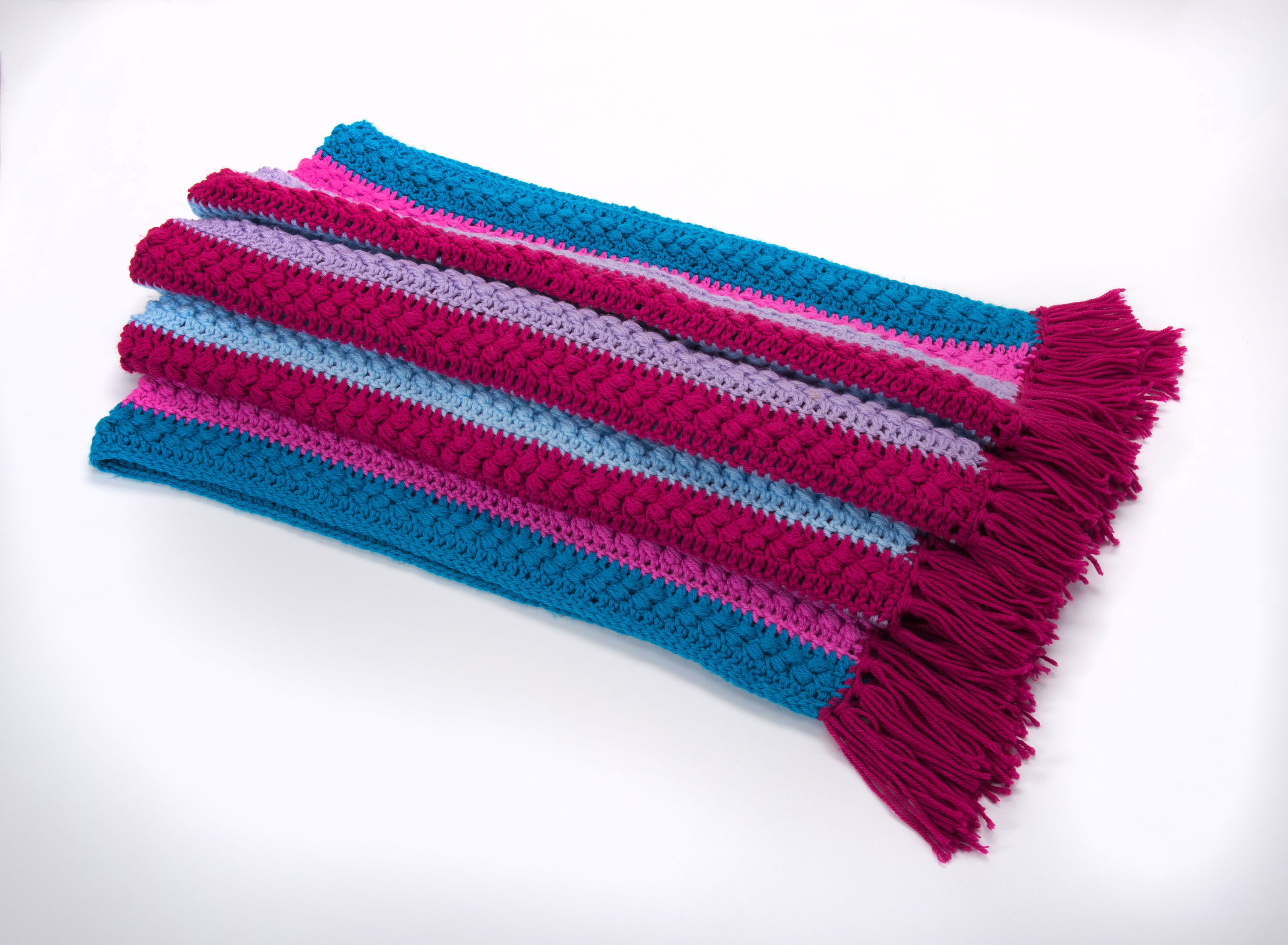 A blue and pink crocheted blanket with fringes in Ottawa at the Canadian Museum of History.