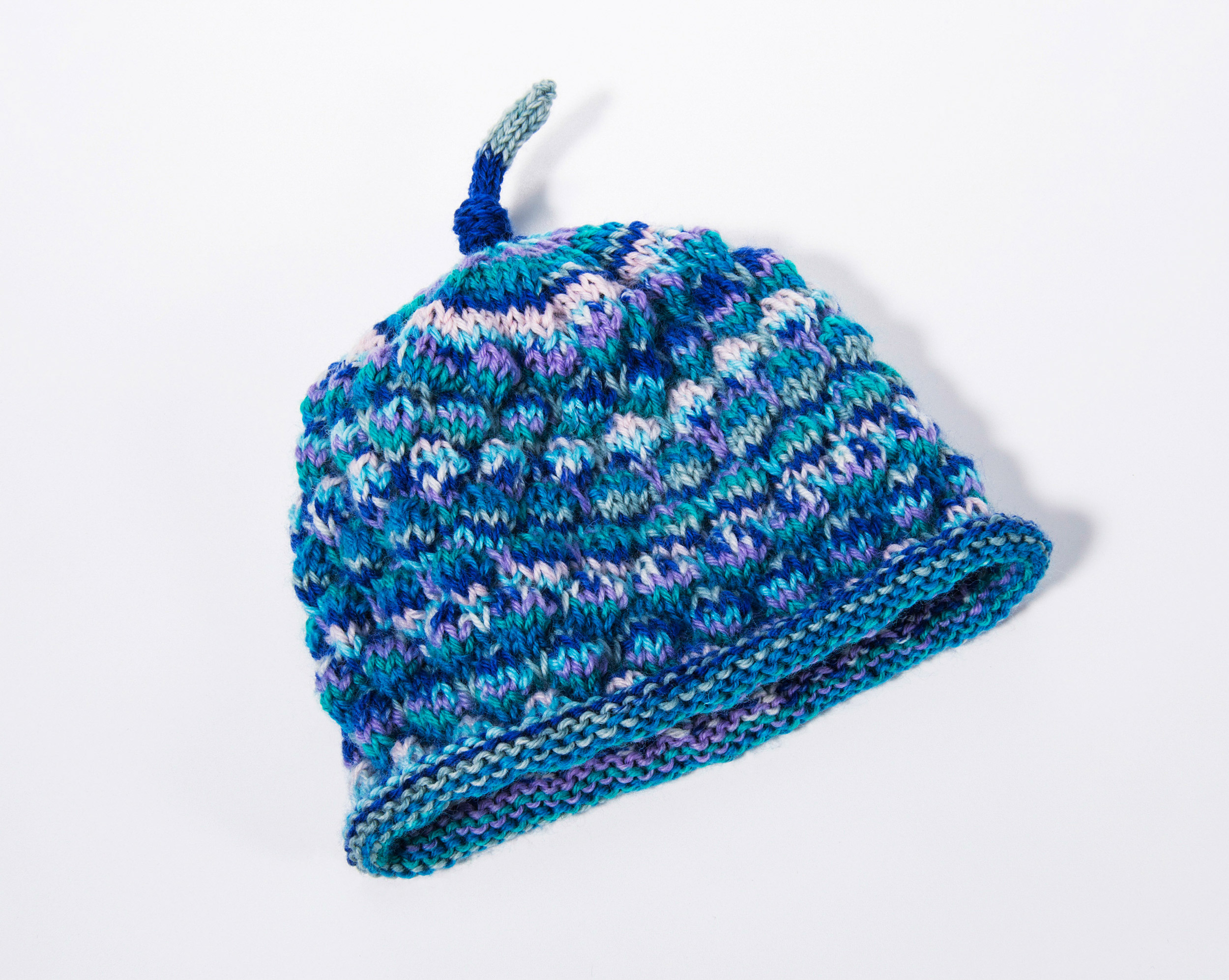 A knitted hat displayed on a white surface in Ottawa at the Canadian Museum of History.