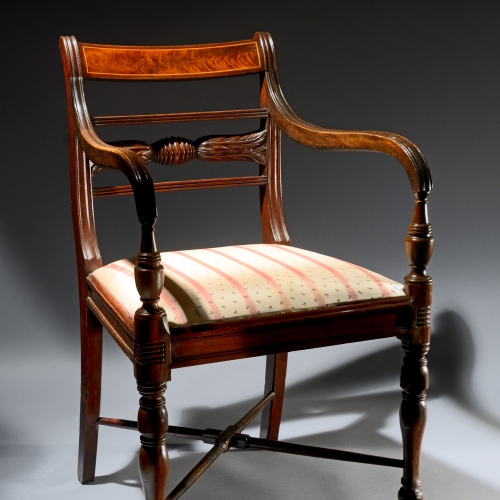 An antique mahogany chair with a striped upholstered seat on display at the Canadian Museum of History in Ottawa.