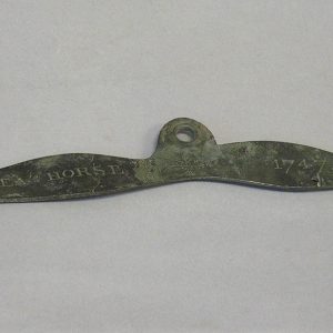 Corroded metal plate with three holes and the inscription Sea Horse 1747