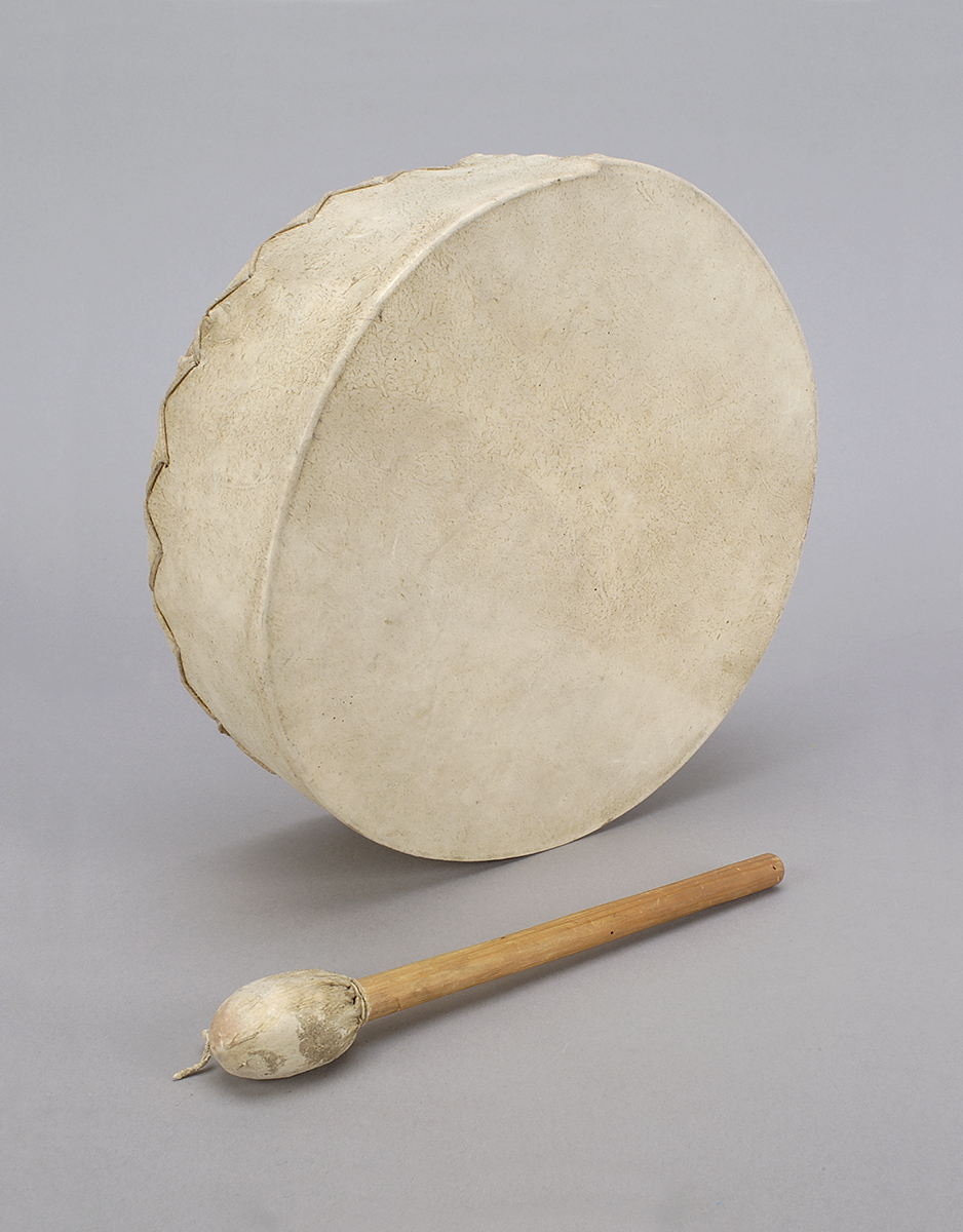 A drum with a wooden stick next to it, on display at the Canadian Museum of History in Ottawa.