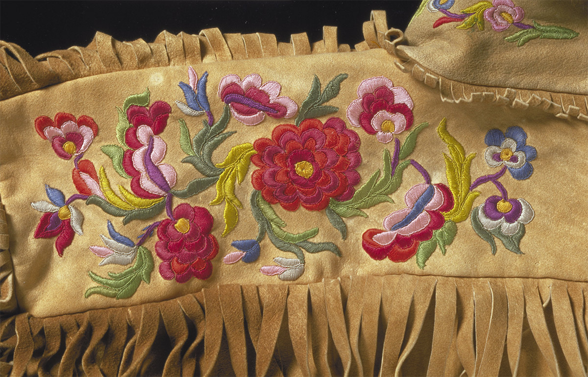 A tan blanket with embroidered flowers and fringes showcased at the Canadian Museum of History in Ottawa.