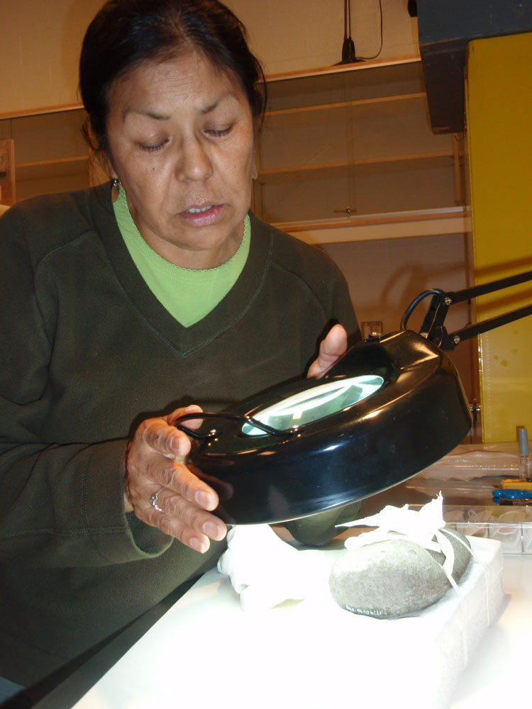 A woman holding a magnifying glass at the Canadian Museum of History in Ottawa.