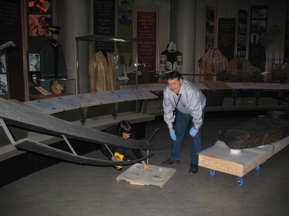 A man wearing a blue shirt reviewing an artifact at the Canadian Museum of History in Ottawa.