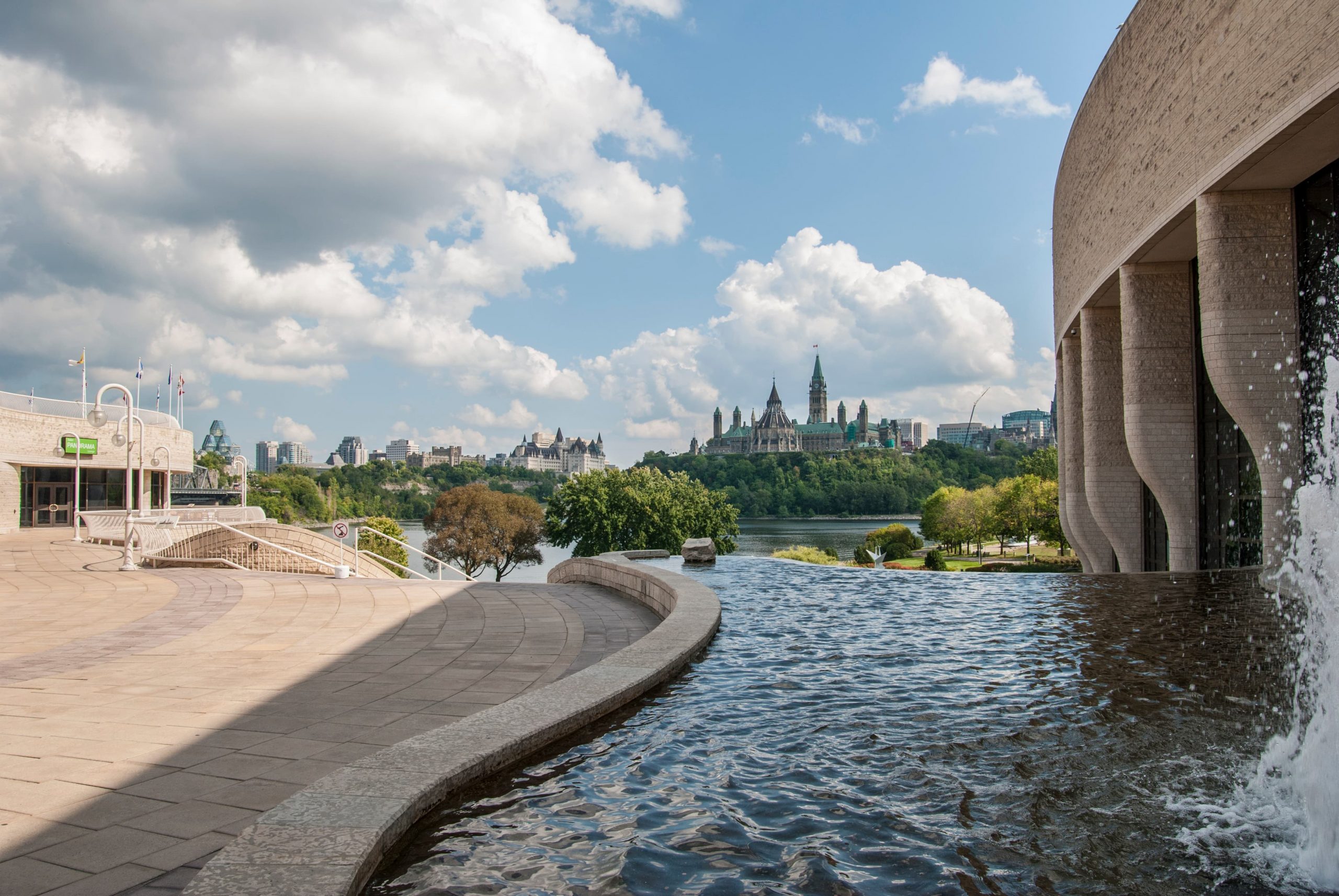 A fountain in front of the Canadian Museum of History with a city in the background.