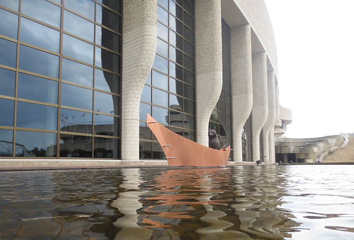 A boat in the water next to the Canadian Museum of History in Ottawa.