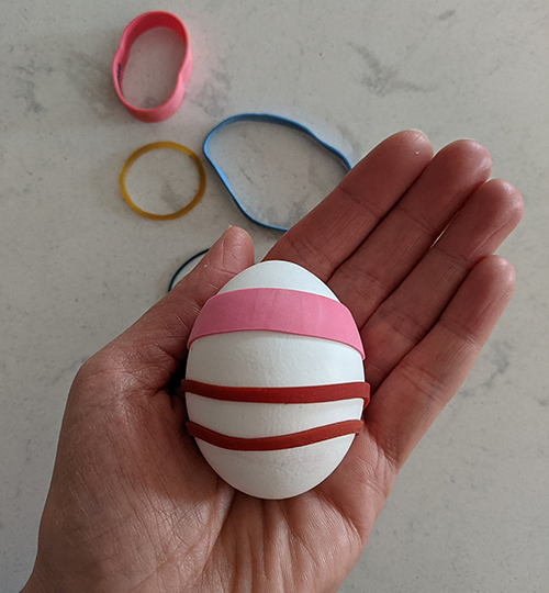 A hand holding a pink and white striped egg at the Canadian Museum of History in Ottawa.