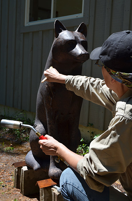 A woman painting a statue of a wolf at the Canadian Museum of History in Ottawa.