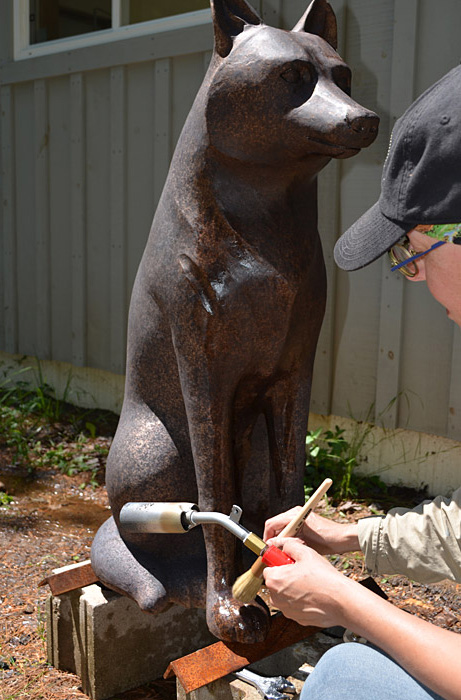 A woman sculpting a statue of a wolf at the Canadian Museum of History in Ottawa.