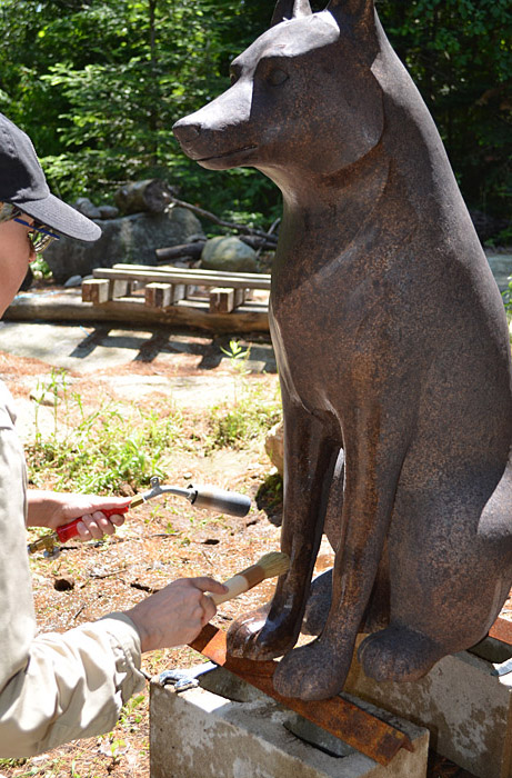 A woman painting a statue of a wolf at the Canadian Museum of History in Ottawa.