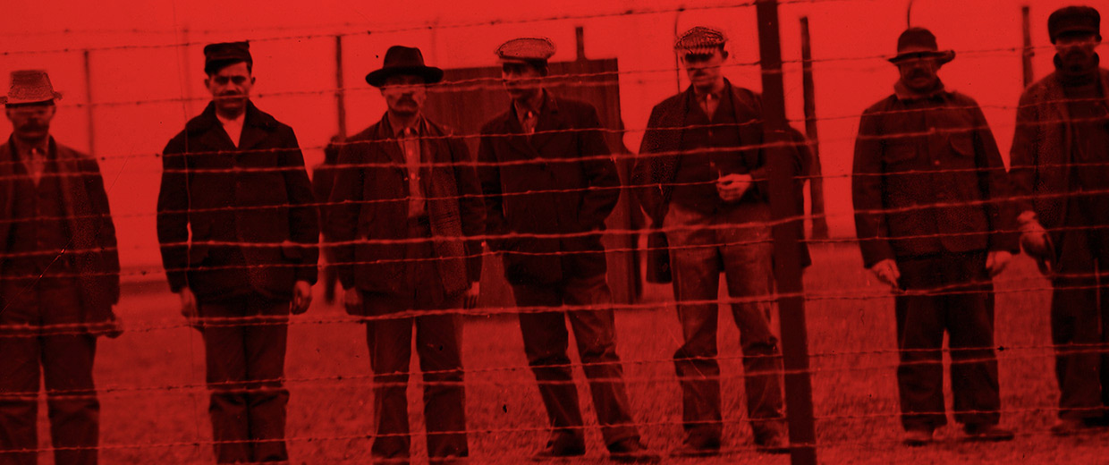 A group of men standing in front of a barbed wire fence at the Canadian War Museum in Ottawa.