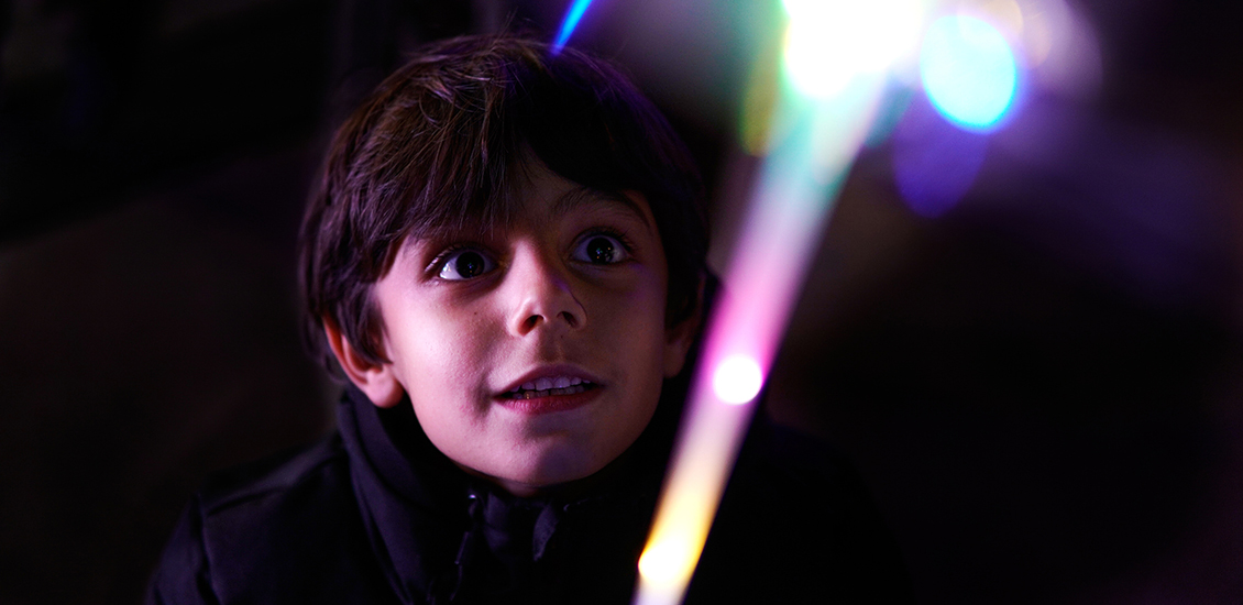 A boy looking at coloured lights