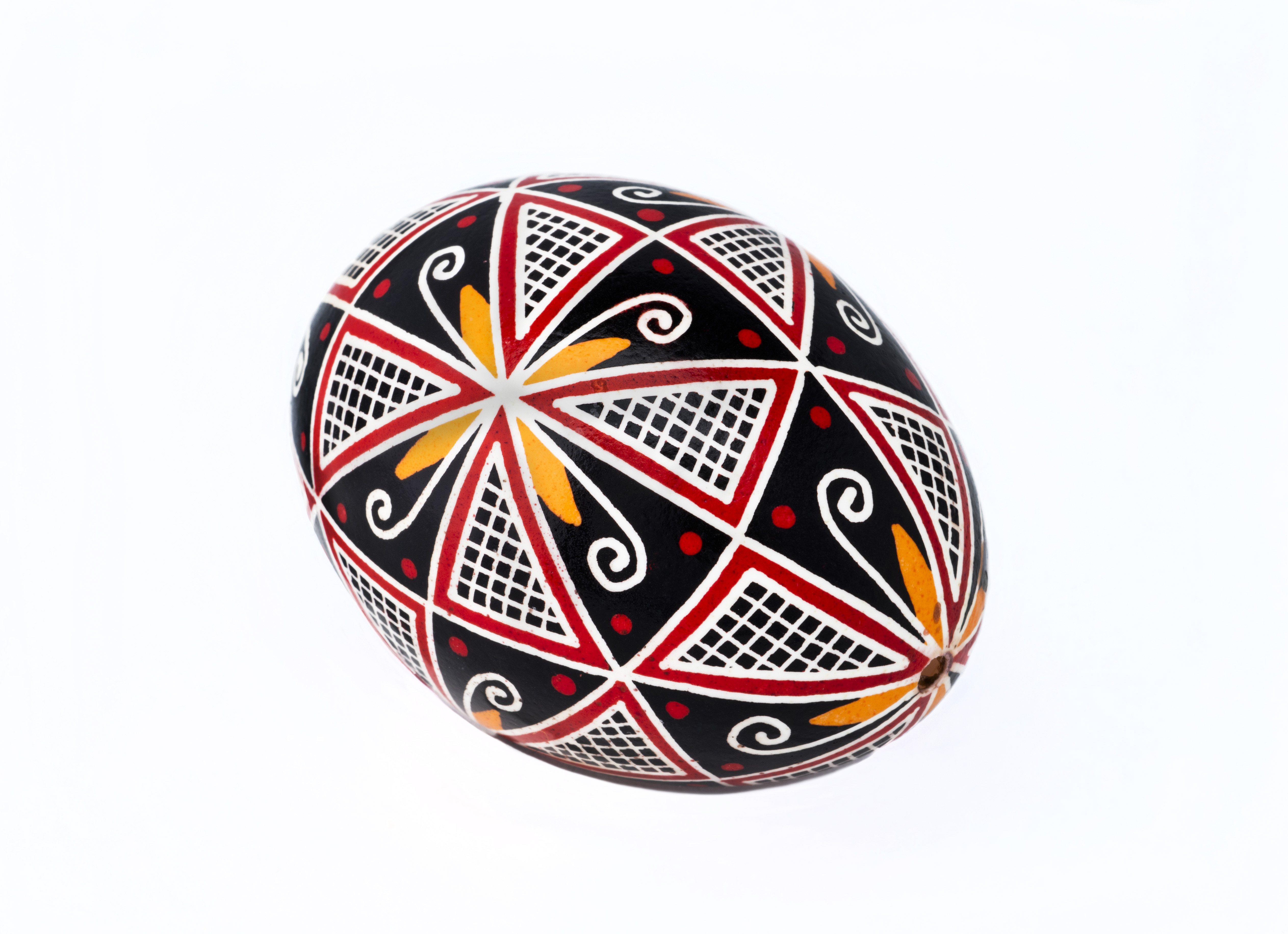 Œuf avec des motifs géométriques rouges, jaunes et noirs//Egg with red, yellow and black geometric patterns