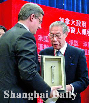 Prime Minister Stephen Harper is presented with an iron spike by James Pon