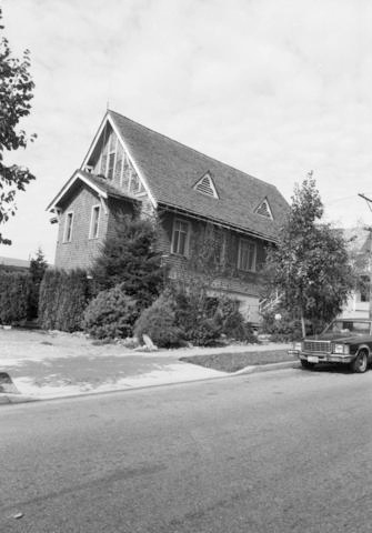 Black-and-white photograph of a church with a car parked in front.