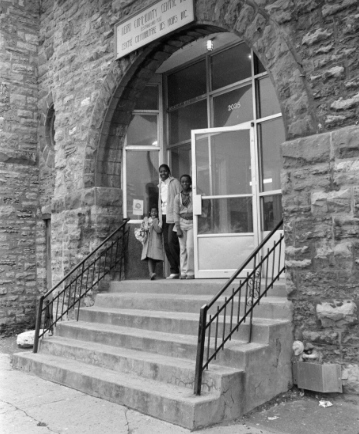 Black-and-white photograph of three people leaving the Union United Church building.